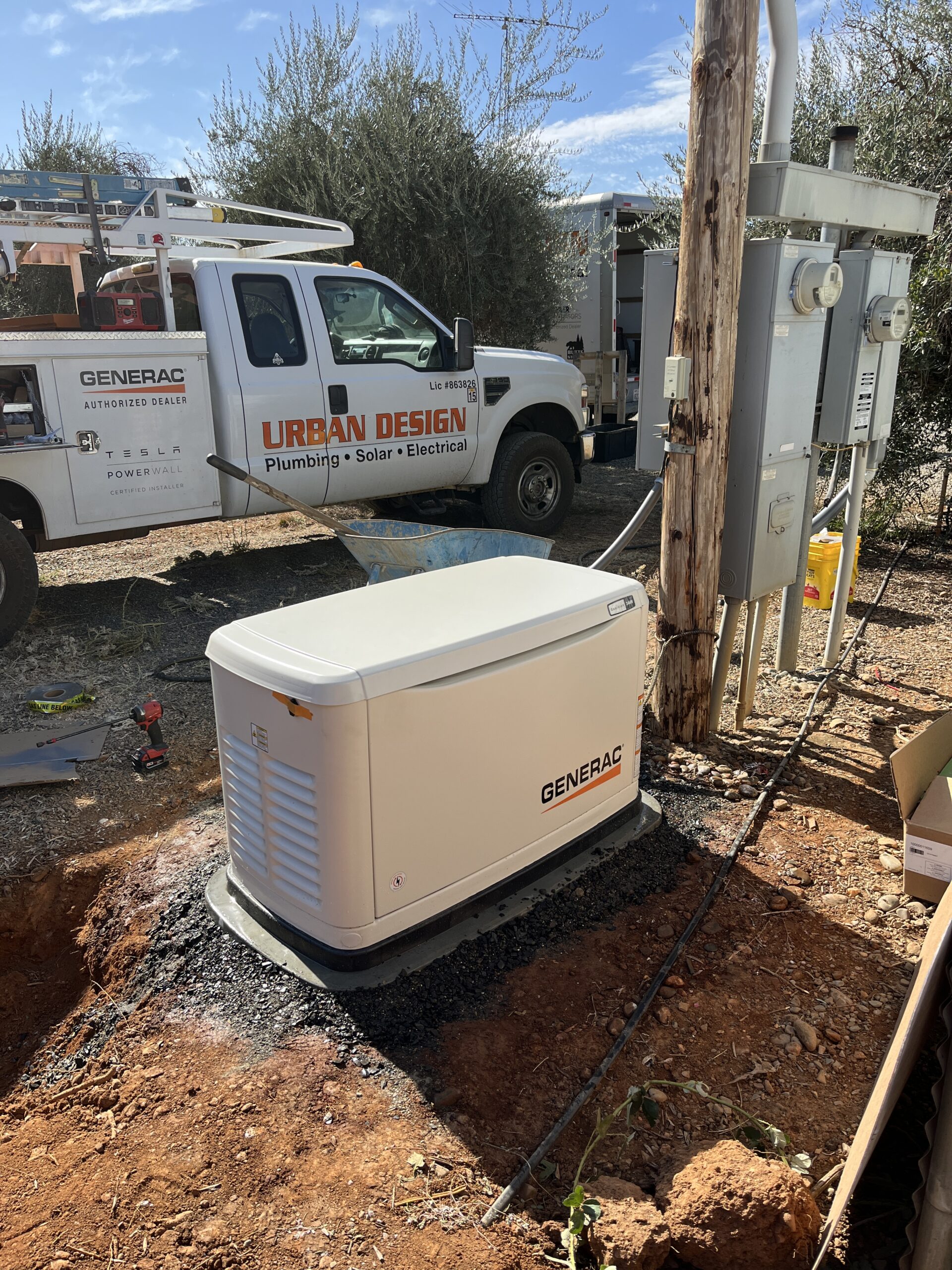 Generac standby generator installed on a pad near an electrical meter, with an Urban Design service truck in the background