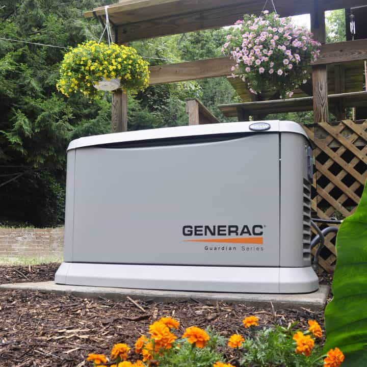Generac Guardian standby generator installed beside a residential deck with landscaping